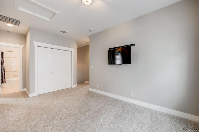 unfurnished bedroom with light carpet and a closet