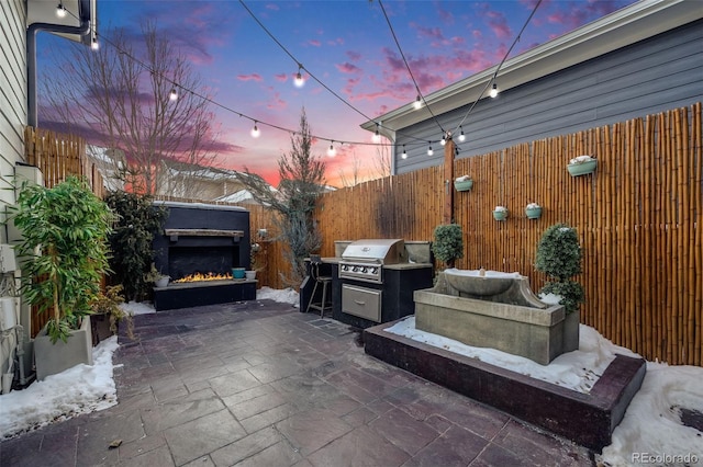 patio terrace at dusk featuring a grill