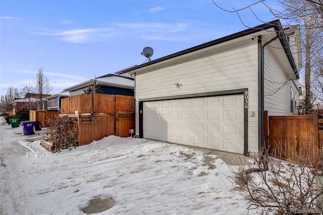 snow covered property featuring a garage