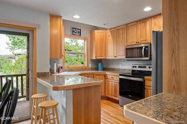 129 Logger Ln, Winter Park, CO 80482 - kitchen with appliances with stainless steel finishes, a peninsula, tile counters, healthy amount of natural light, and recessed lighting