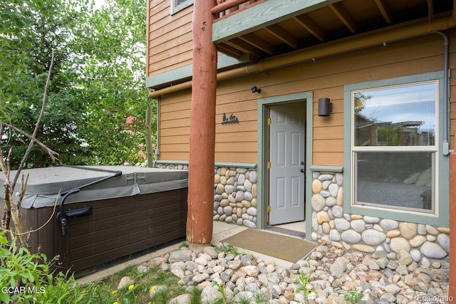 129 Logger Ln, Winter Park, CO 80482 - view of exterior entry featuring a hot tub and stone siding