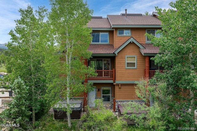 129 Logger Ln, Winter Park, CO 80482 - rear view of house with a shingled roof, stone siding, and a balcony