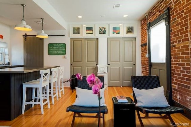 2801 Champa St, Denver, CO 80205 - living area with brick wall, light wood-style flooring, and ceiling fan