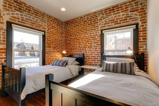 2801 Champa St, Denver, CO 80205 - bedroom with multiple windows, wood finished floors, brick wall, and recessed lighting