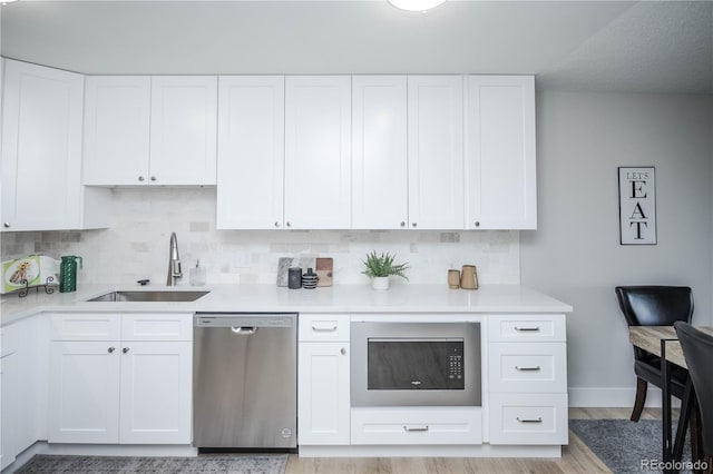 kitchen with dishwasher, white cabinets, and sink