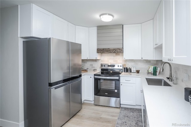 kitchen featuring backsplash, white cabinets, sink, appliances with stainless steel finishes, and custom range hood