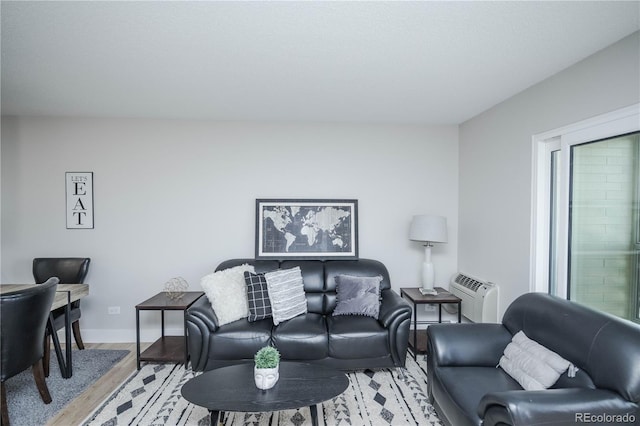 living room featuring an AC wall unit and light hardwood / wood-style floors