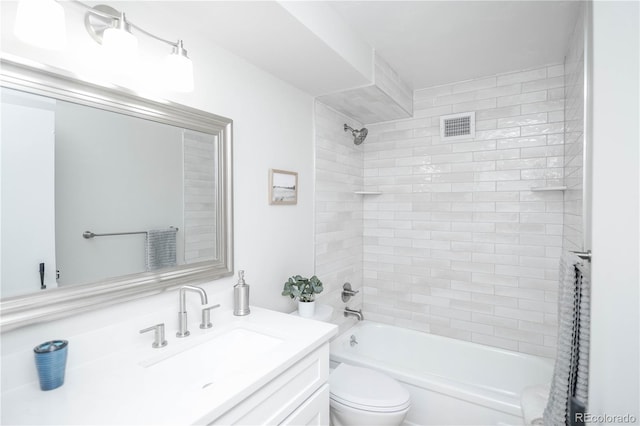 full bathroom with toilet, vanity, and tiled shower / bath