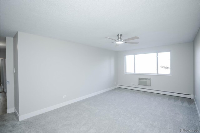 carpeted spare room with ceiling fan, a textured ceiling, a wall mounted AC, and a baseboard heating unit