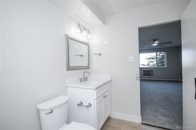 bathroom featuring vanity, hardwood / wood-style flooring, toilet, and ceiling fan