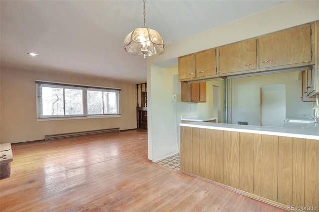 kitchen with light hardwood / wood-style flooring, a notable chandelier, a baseboard heating unit, kitchen peninsula, and decorative light fixtures