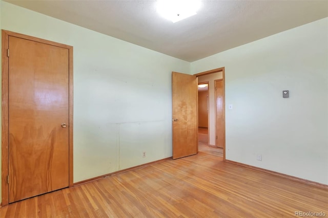 unfurnished bedroom featuring a closet and light wood-type flooring