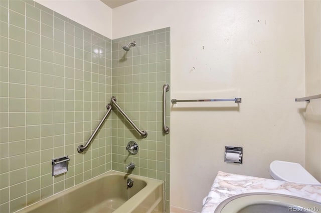 full bathroom featuring toilet, tiled shower / bath, and sink