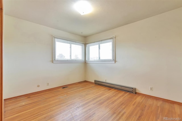 spare room with light wood-type flooring and a baseboard radiator