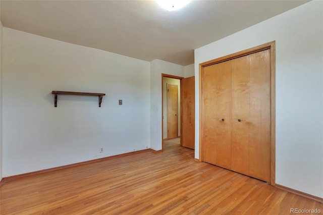 unfurnished bedroom with light hardwood / wood-style flooring and a closet