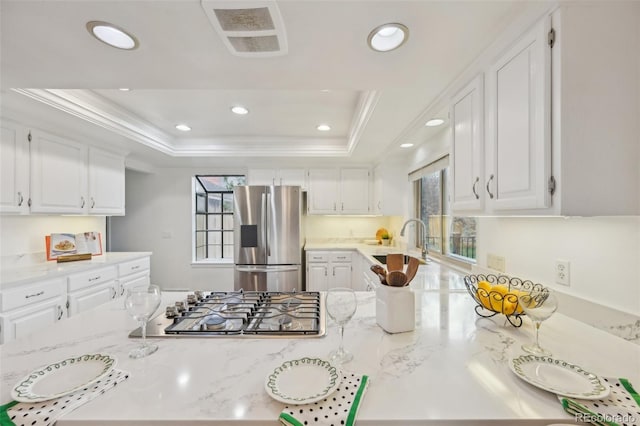 8424 E Otero Cir, Centennial, CO 80112 - kitchen featuring stainless steel appliances, a tray ceiling, ornamental molding, white cabinetry, and recessed lighting