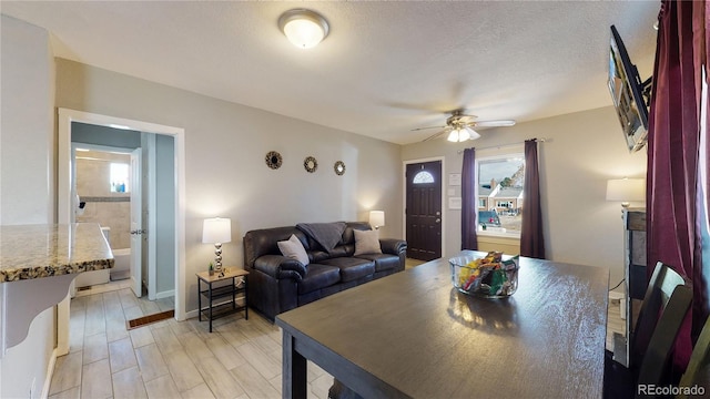 dining area with a textured ceiling, ceiling fan, and light hardwood / wood-style flooring