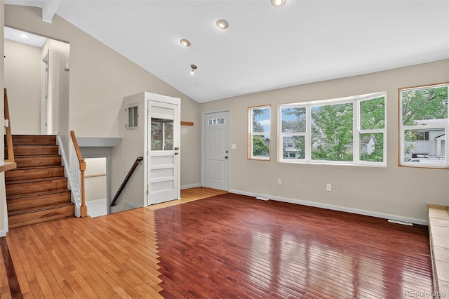 18445 W 59th Dr, Golden, CO 80403 - unfurnished living room with lofted ceiling, hardwood / wood-style flooring, healthy amount of natural light, recessed lighting, and stairs