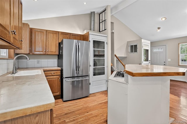 18445 W 59th Dr, Golden, CO 80403 - kitchen featuring appliances with stainless steel finishes, vaulted ceiling, light wood finished floors, light countertops, and brown cabinetry