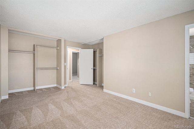 19876 E Brunswick Dr, Aurora, CO 80013 - unfurnished bedroom featuring multiple closets, carpet flooring, ensuite bathroom, and a textured ceiling