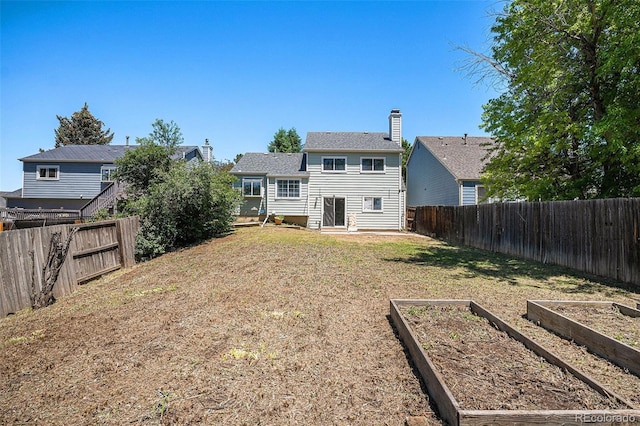 19876 E Brunswick Dr, Aurora, CO 80013 - back of property featuring a garden, a fenced backyard, and a chimney