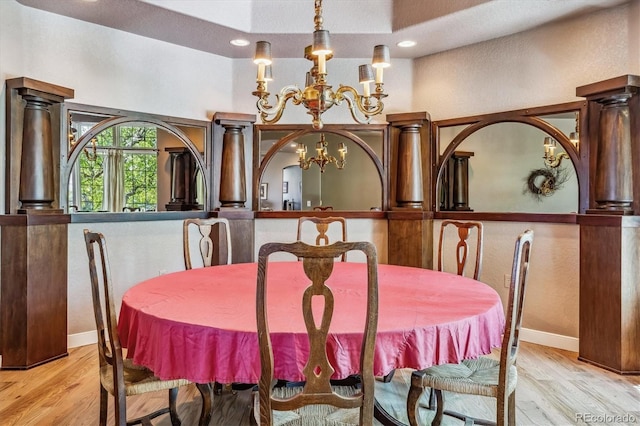 dining area featuring light wood-type flooring and a notable chandelier