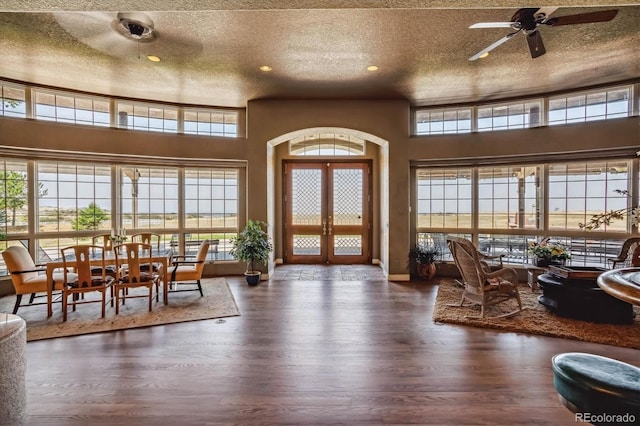 interior space with ceiling fan, dark hardwood / wood-style floors, french doors, and a textured ceiling