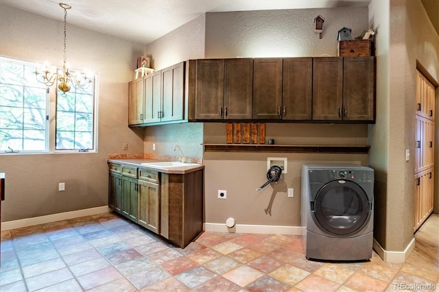 laundry area featuring an inviting chandelier, cabinets, washer / clothes dryer, and sink