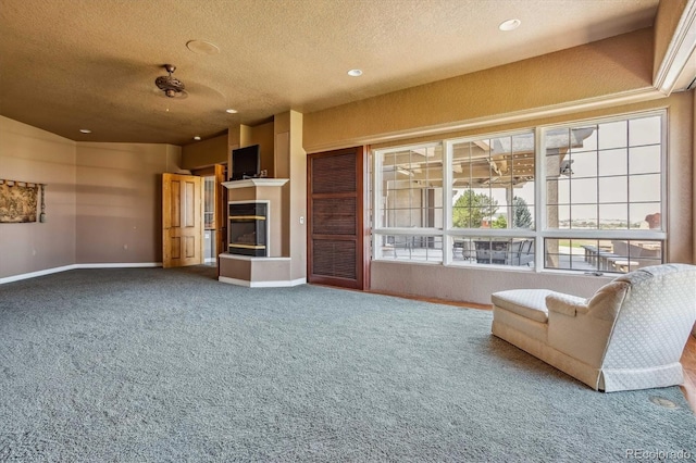 unfurnished living room with carpet floors and a textured ceiling