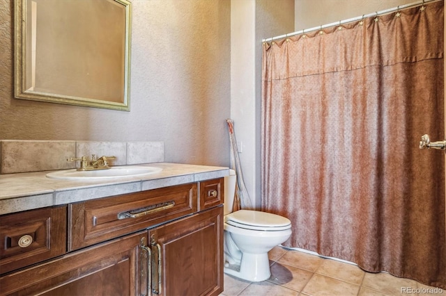 bathroom featuring tile patterned flooring, vanity, and toilet