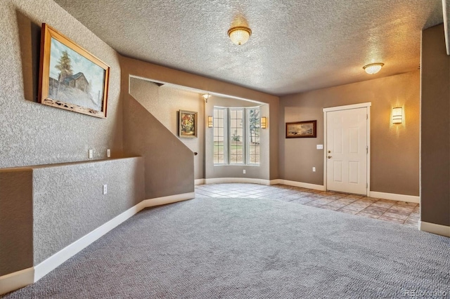 foyer with light carpet and a textured ceiling