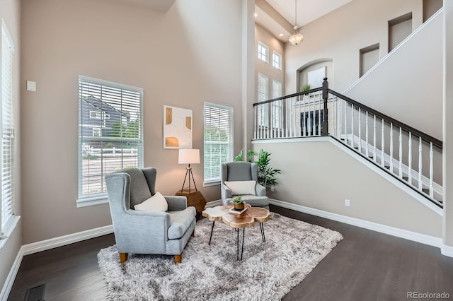 8469 Winter Berry Dr, Castle Pines, CO 80108 - living area with a towering ceiling, wood finished floors, baseboards, and healthy amount of natural light