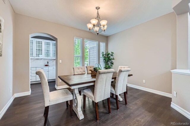 8469 Winter Berry Dr, Castle Pines, CO 80108 - dining area featuring a chandelier, dark wood-type flooring, and baseboards