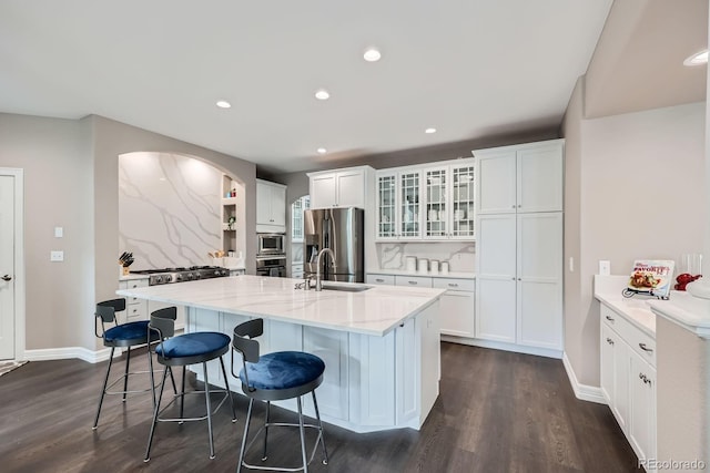 8469 Winter Berry Dr, Castle Pines, CO 80108 - kitchen featuring appliances with stainless steel finishes, dark wood finished floors, a kitchen bar, white cabinetry, and recessed lighting