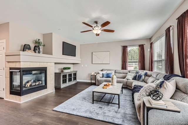 8469 Winter Berry Dr, Castle Pines, CO 80108 - living area with a ceiling fan, wood finished floors, a tile fireplace, and baseboards