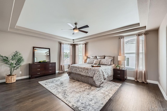 8469 Winter Berry Dr, Castle Pines, CO 80108 - bedroom with a tray ceiling, dark wood finished floors, and baseboards