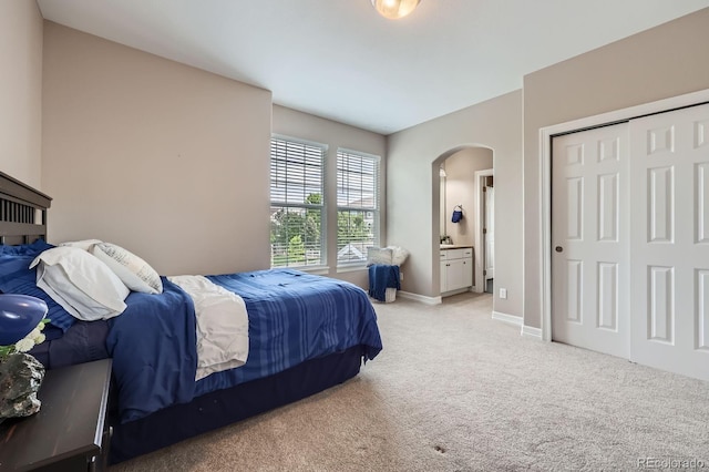 8469 Winter Berry Dr, Castle Pines, CO 80108 - bedroom with arched walkways, light carpet, baseboards, a closet, and ensuite bathroom