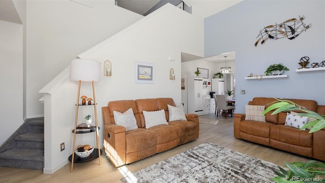 living area featuring stairway, a high ceiling, and wood finished floors