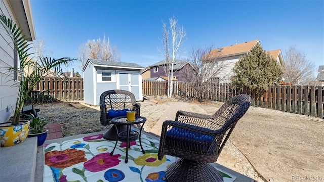 view of patio / terrace with an outbuilding, a storage unit, and a fenced backyard