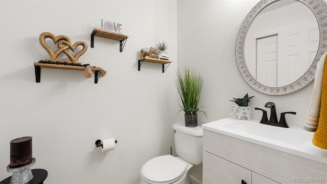 half bathroom with vanity and toilet