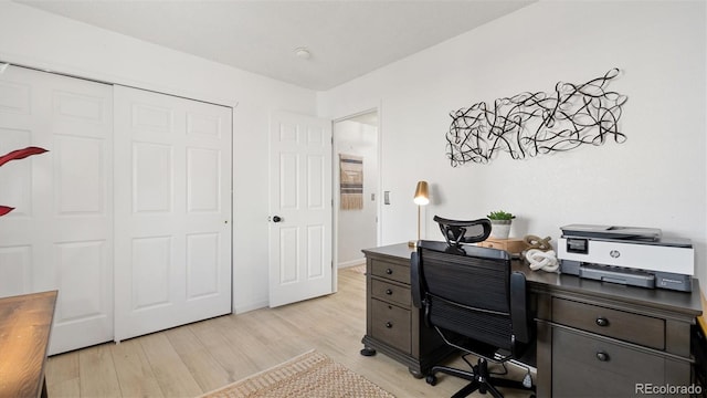 home office with baseboards and light wood-type flooring