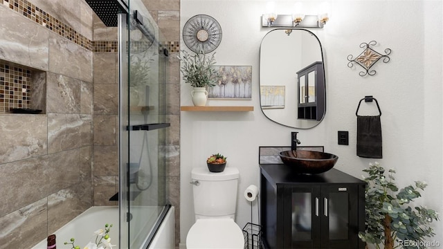 bathroom featuring vanity, toilet, and combined bath / shower with glass door