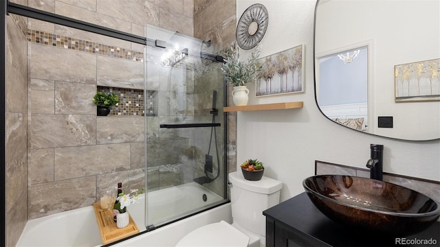 full bath featuring toilet, vanity, and bath / shower combo with glass door