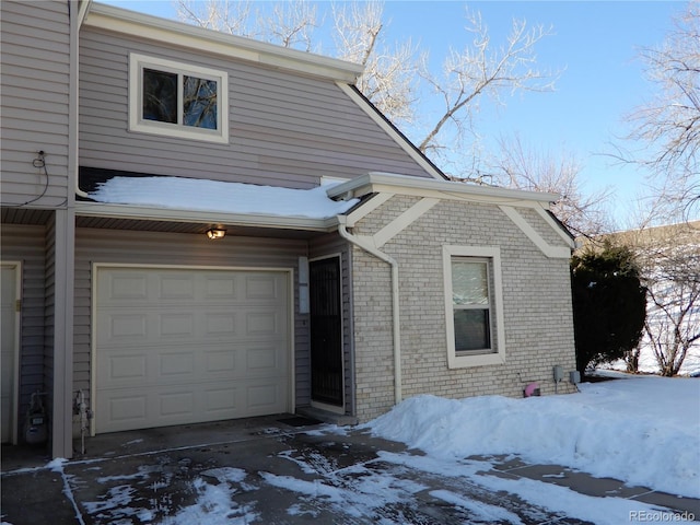 snow covered property featuring a garage