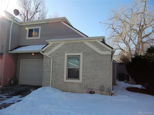 view of snow covered exterior featuring a garage