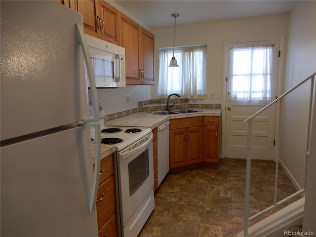 kitchen with sink, white appliances, and decorative light fixtures