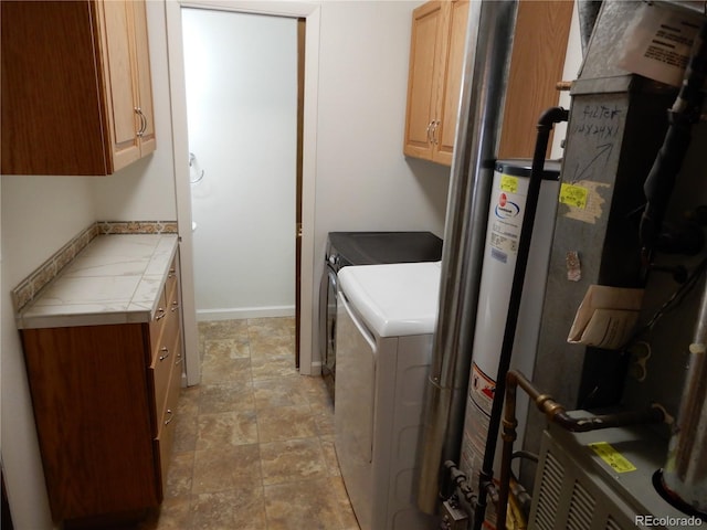 laundry room with cabinets, gas water heater, and washing machine and clothes dryer