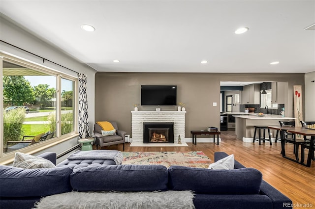 2845 Hudson St, Denver, CO 80207 - living room featuring recessed lighting, light wood-style floors, healthy amount of natural light, and a fireplace