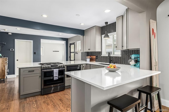 2845 Hudson St, Denver, CO 80207 - kitchen featuring range with two ovens, gray cabinetry, a peninsula, light countertops, and recessed lighting