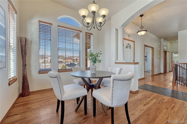 dining area featuring a wealth of natural light, arched walkways, and wood finished floors